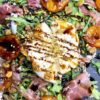 Close up of apricot salad with burrata pistachios and balsamic drizzle
