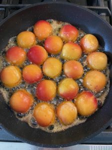Adding apricot halves side down to melted butter