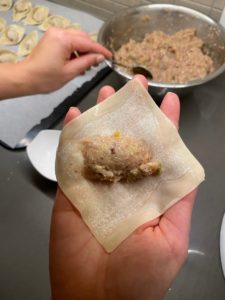 Add lukewarm water in a small bowl.  Lightly wet all sides of the wonton wrapper.  Put one small spoonful of filling into the middle of the wrapper. Avoid overfilling as they may come undone or the wrapper may break during cooking. 