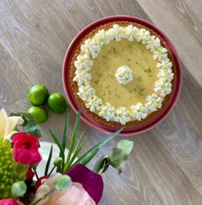 Lime tart on display with limes and flowers