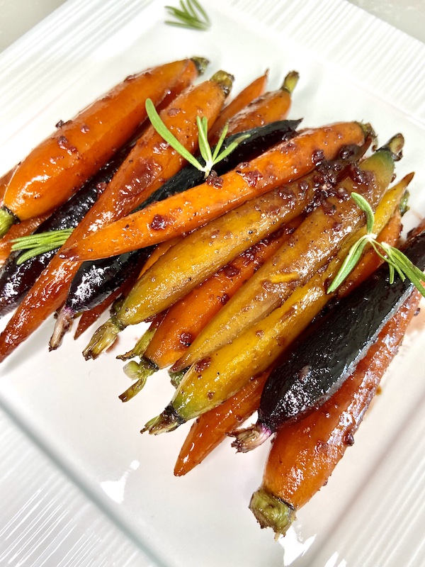 Rainbow carrots on plate with rosemary sprigs