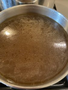 Passing the broth through a strainer to obtain a clear broth