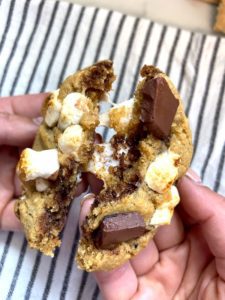 Close up of s'mores cookie cut into showcasing the gooey marshmallows
