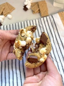 Chocolate chip s'mores cookie cut into showcasing the gooey marshmallows