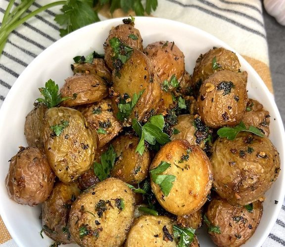 Close up of oven roasted mini potatoes in a bowl on dish towel