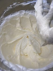 Making Italian buttercream -Adding dollops of butter into the meringue to make italian buttercream. Halfway through, the consistency is "soupy" but it's normal.