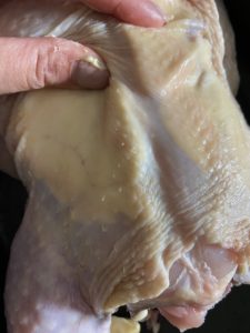 Spreading butter on chicken breasts