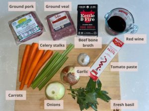 Ingredient list for making Veal & Pork Ragù: ground pork, ground veal, beef bone broth, red wine, tomato paste, fresh basil leaves, garlic, onions, celery stalks and carrots