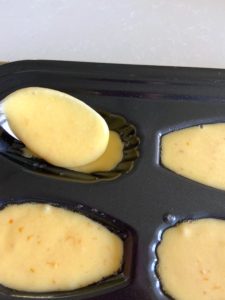 Spooning cake batter into pan.