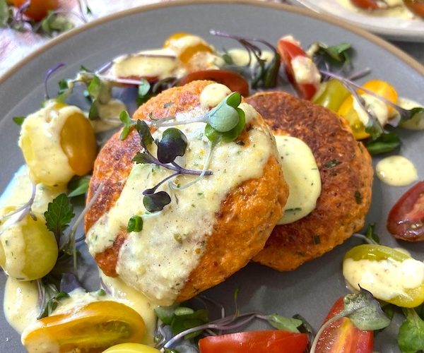 Close up picture of salmon cakes served with sauce gribiche
