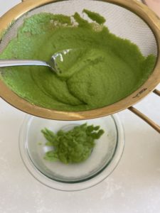 Straining the pea puree to make it extra smooth