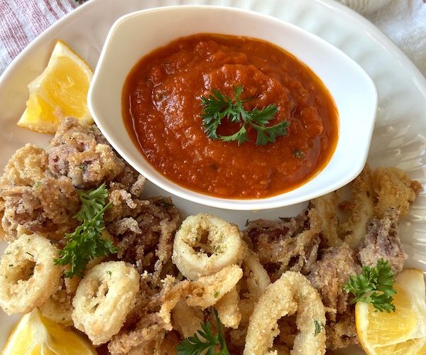 Plate of fried calamari with marinara sauce.