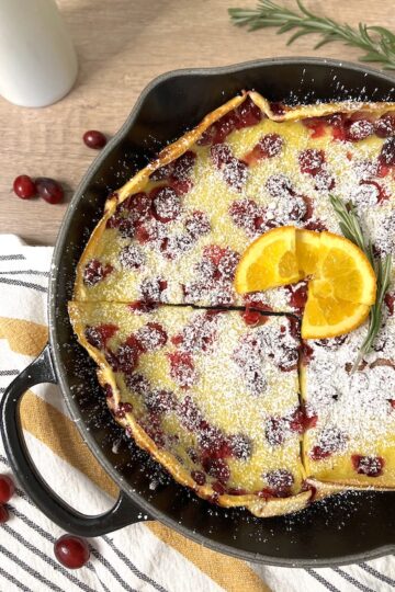 An iron skillet with the Cranberry ornage Ducth baby with a quarter slice