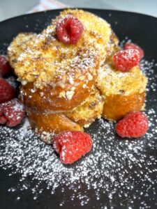Three pieces of French toasts with raspberries