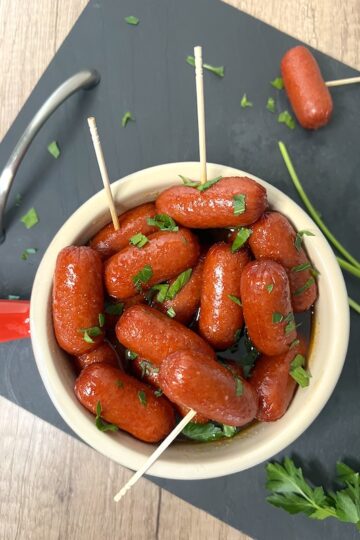 Sausages with toothpicks as appetizers in a bowl.