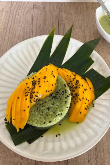 Plate of Pandan sticky rice with sliced mangoes.