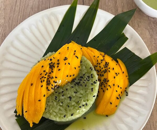 Plate of Pandan sticky rice with sliced mangoes.